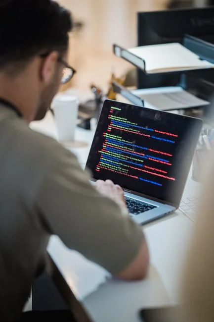Dual monitors on a desk, showcasing web design in a modern office setting.